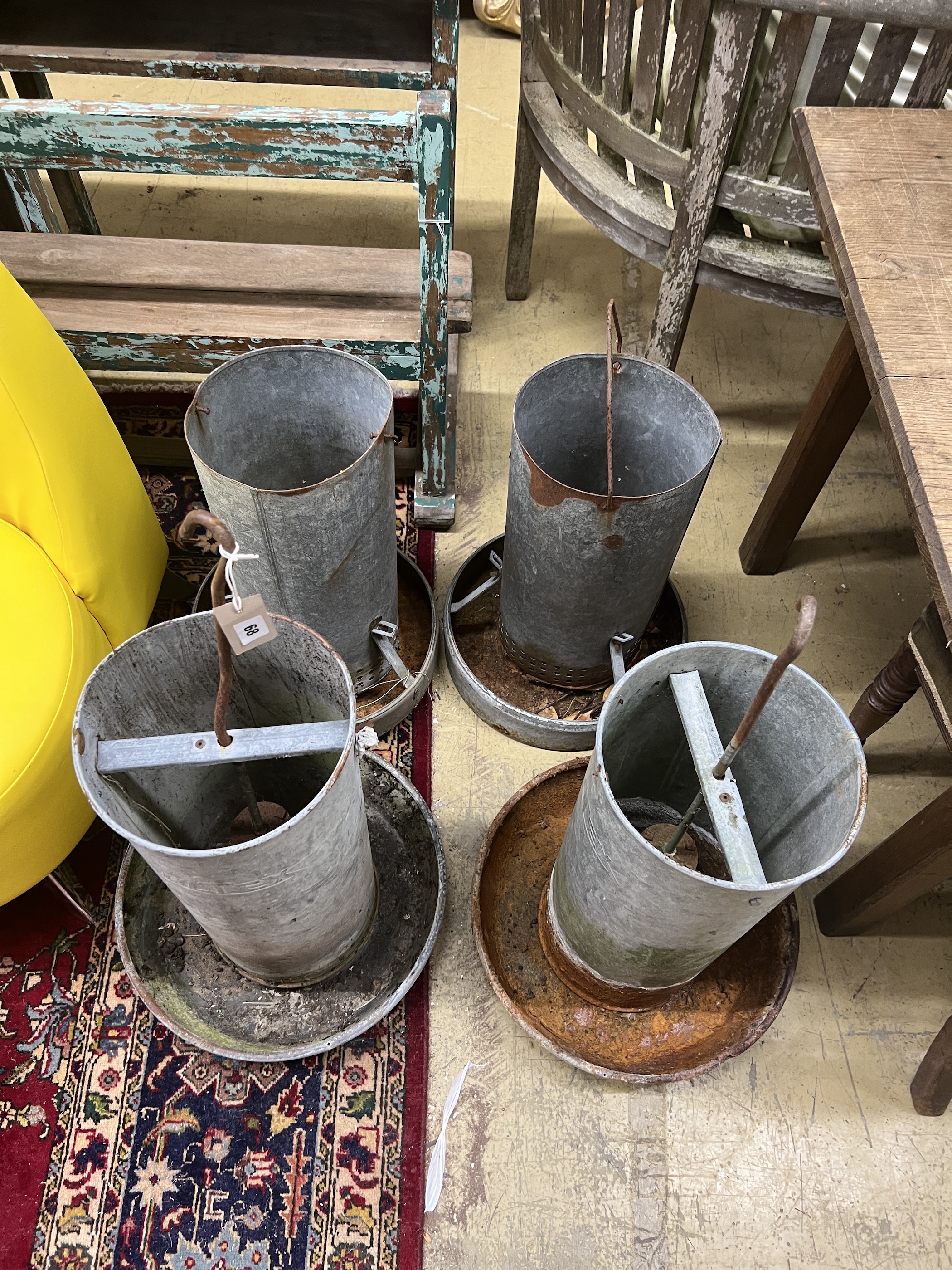 Four vintage galvanised poultry feeders, largest height 62cm